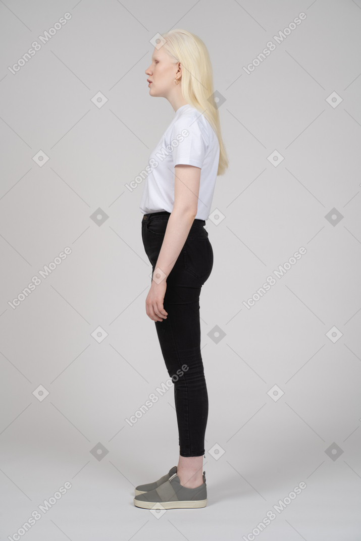 Side view of a young blonde girl standing