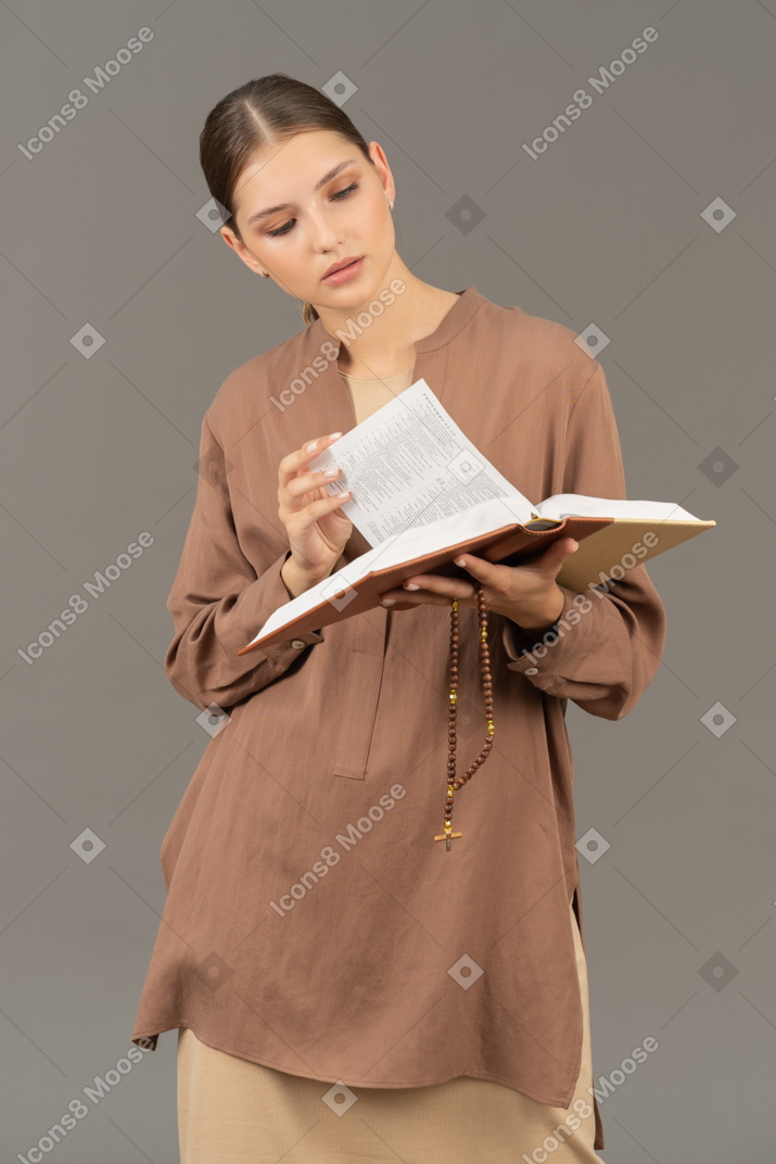 Mujer joven concentrada leyendo un libro