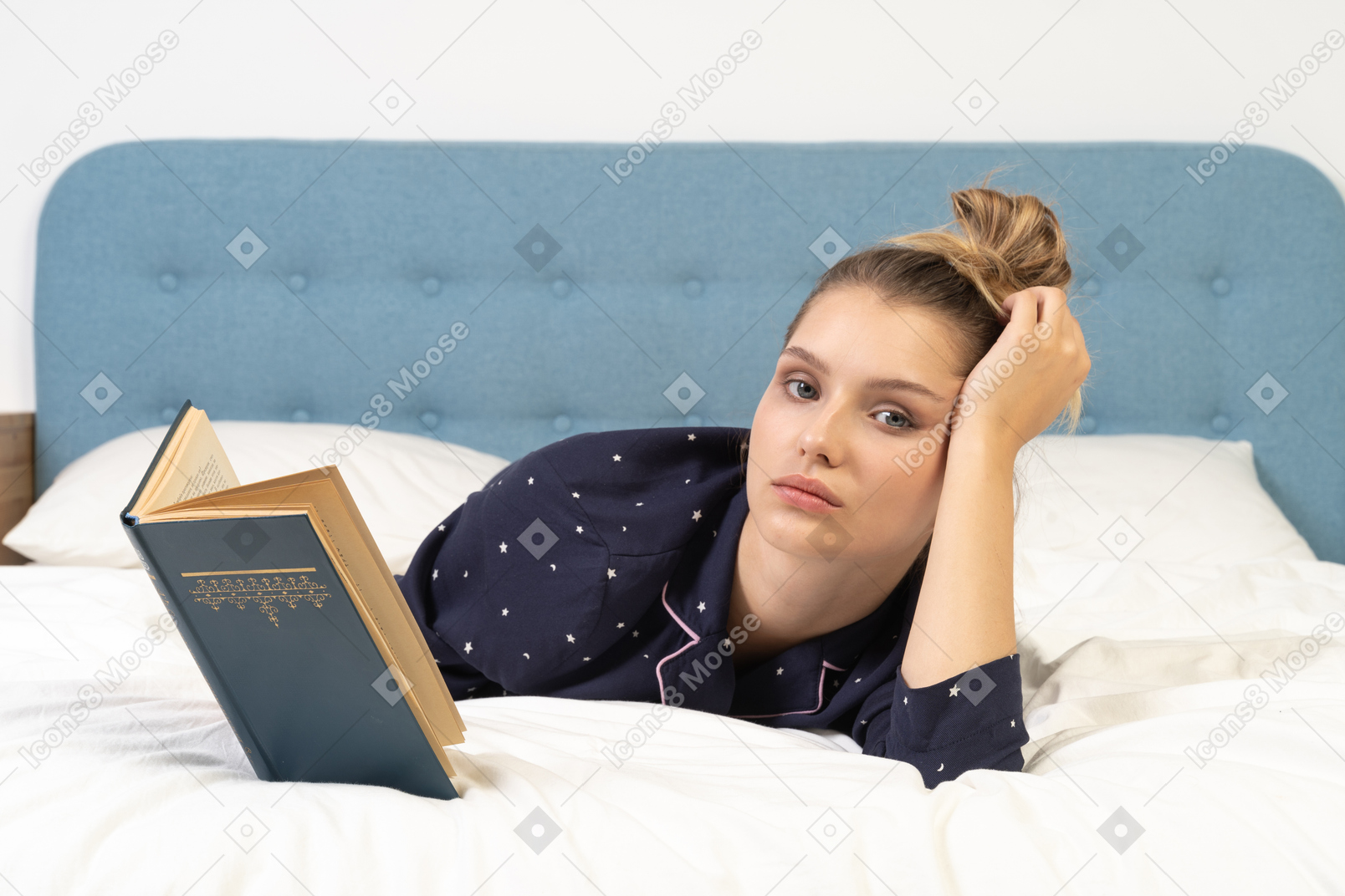 Vista frontal de uma jovem lendo livro feminino na cama