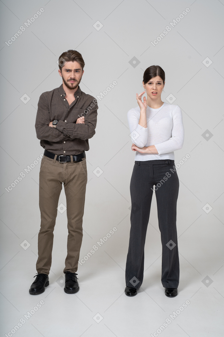 Front view of an arrogant man and questioning woman in office clothing