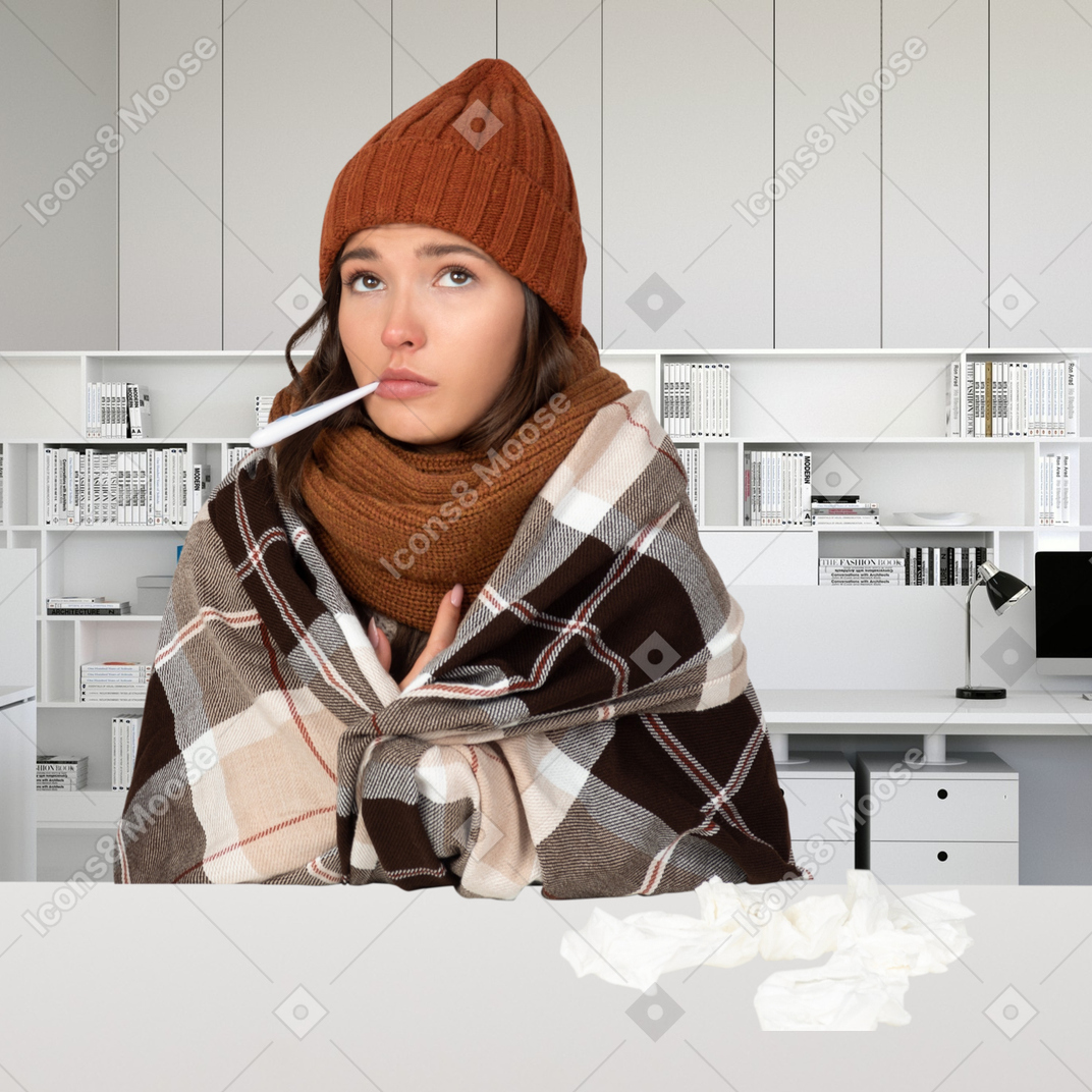 A sick woman is sitting with thermometer in mouth