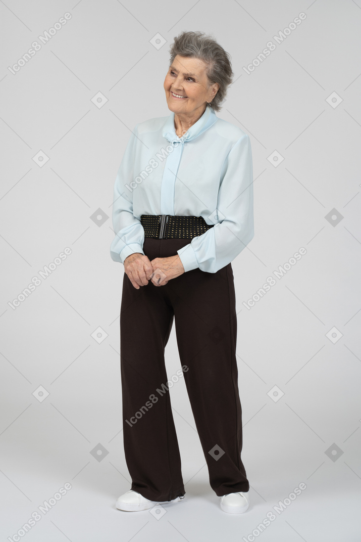 Вид в три четверти на пожилую женщину, улыбающуюся со сложенными руками