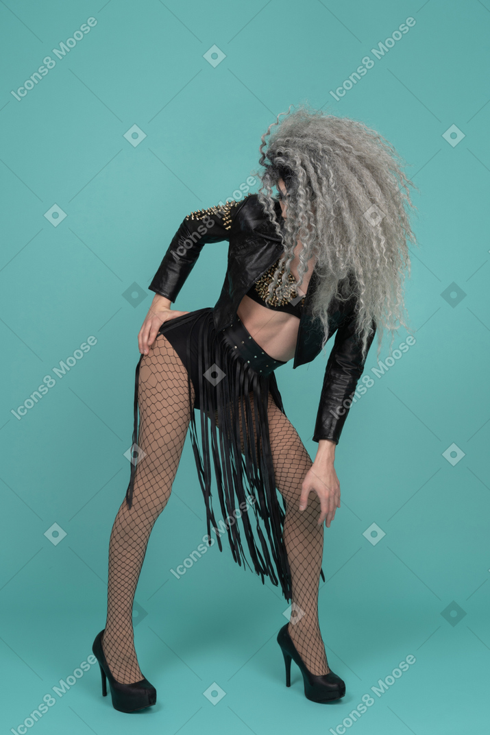 Drag queen in all black outfit with hair covering face