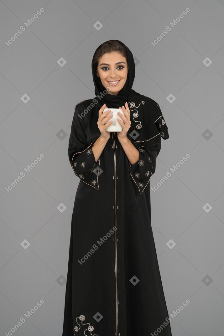 Cheerful young woman holding a cup