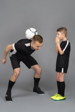 De cuerpo entero de un joven entrenando a un niño