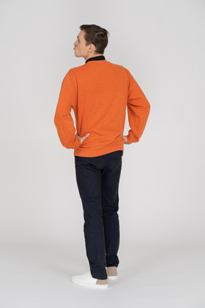 Joven en sudadera naranja de pie