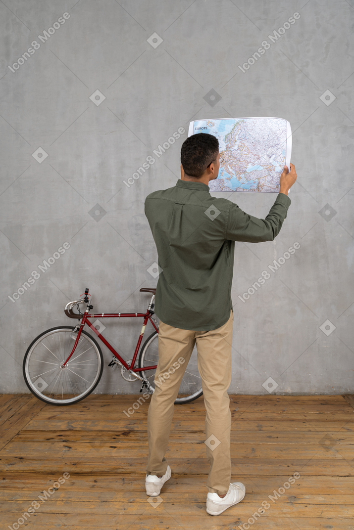 一个男人检查地图的四分之三后视图