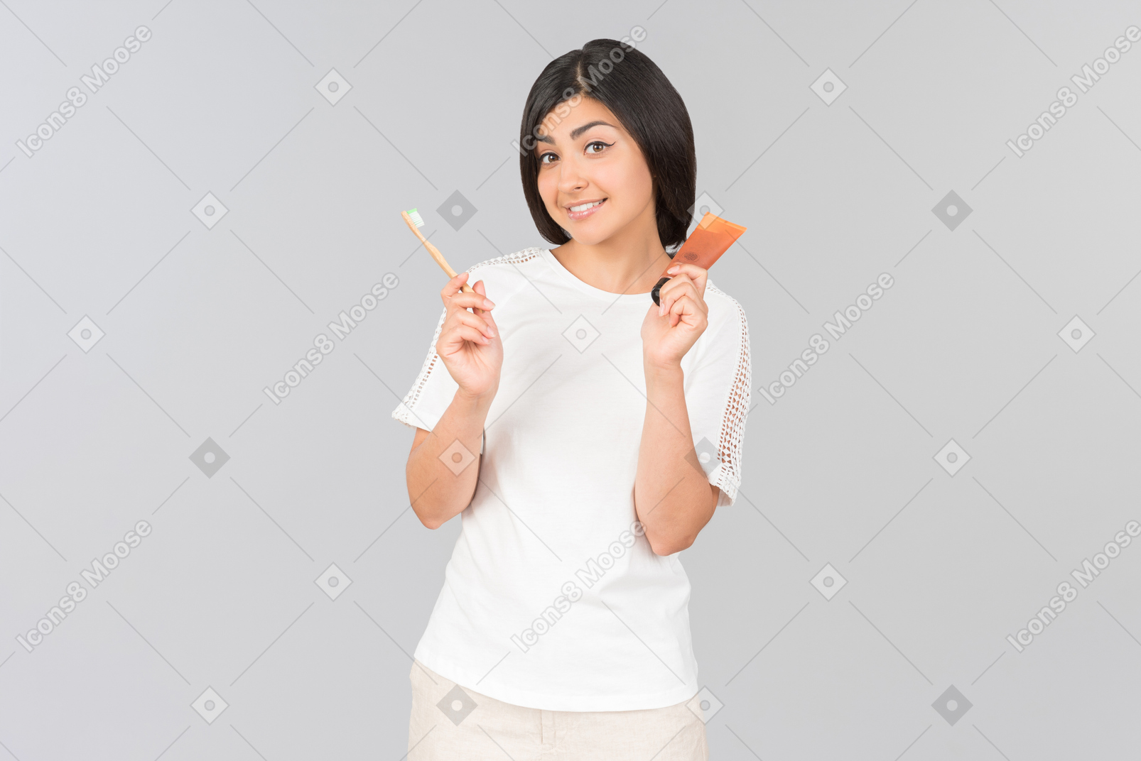 Young indian woman holding toothpaste and toothbrush