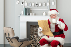 圣诞老人阅读与一杯咖啡的礼物清单