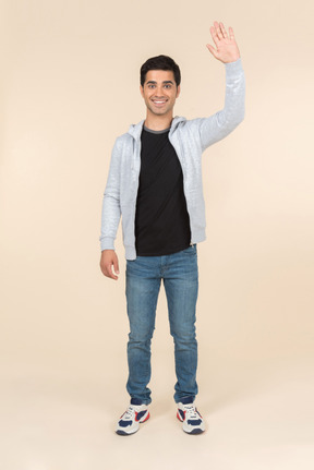 Young caucasian man smiling and waving