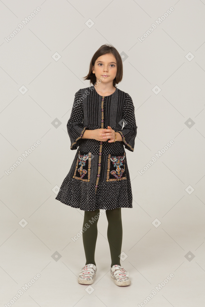 Front view of a little girl in dress looking at camera