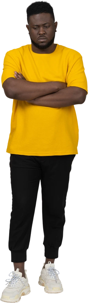 Front view of a young dark-skinned man in yellow t-shirt crossing arms