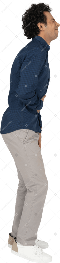 Vista laterale di un uomo in abiti casual che soffre di mal di stomaco