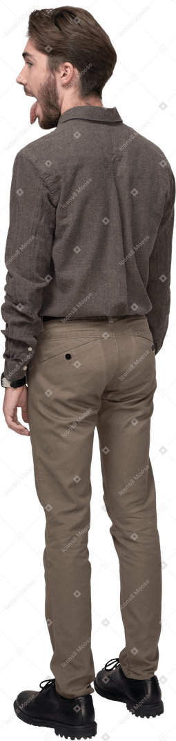 Three-quarter back view of a crazy young man in office clothing showing tongue