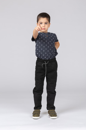 Front view of a cute boy pointing with finger