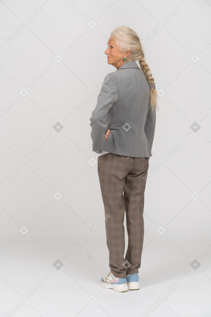 一位身穿灰色夹克的老太太的后视图
