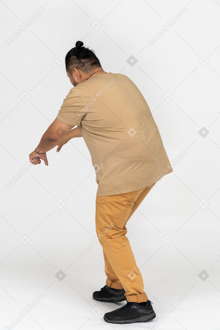 Hombre asiático de talla grande agachándose con la mano extendida