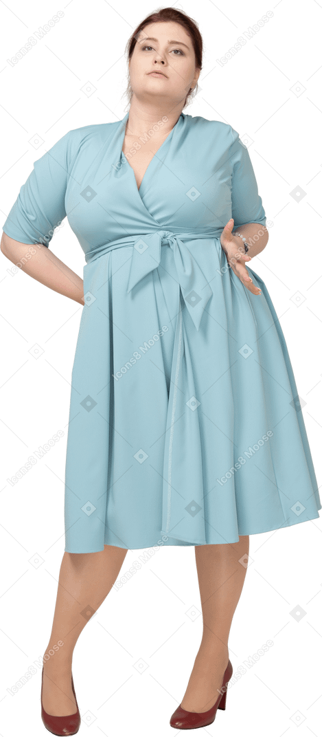 Front view of a woman in blue dress posing with hands on hips