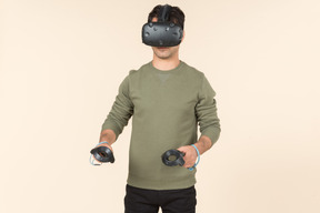 Young caucasian guy playing a virtual reality game