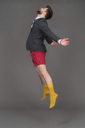 Bearded brunette man levitating in profile