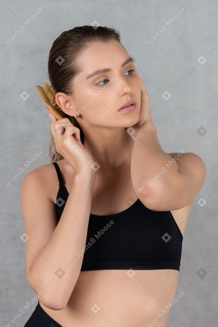 彼女の髪をブラッシングしている若い女性の肖像画