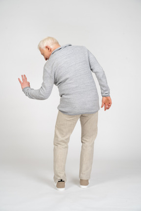 Rear view of man looking aside and showing three fingers