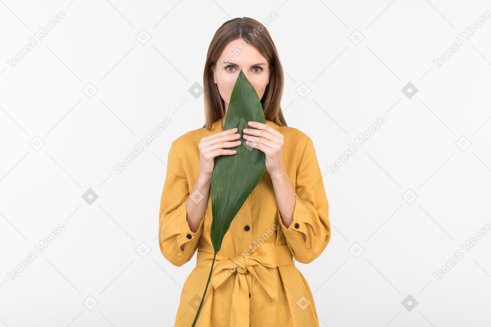 Young woman closing half of a face with green leaf