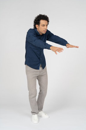 Vista frontale di un uomo in abiti casual in piedi con le braccia tese