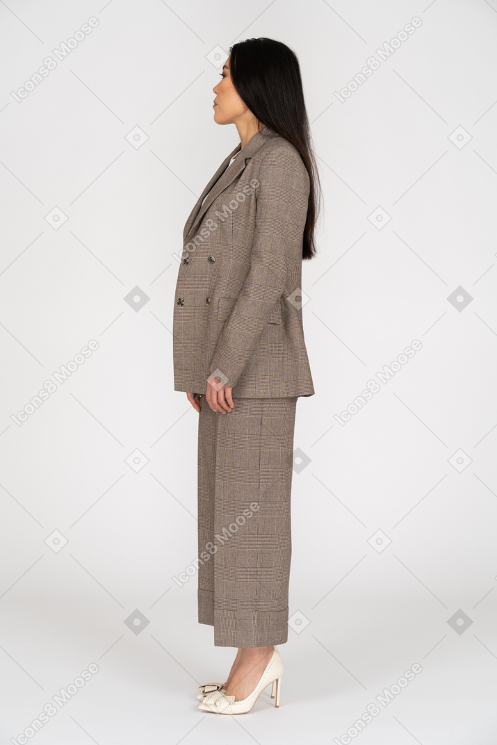 Side view of a young lady in brown business suit  turning head