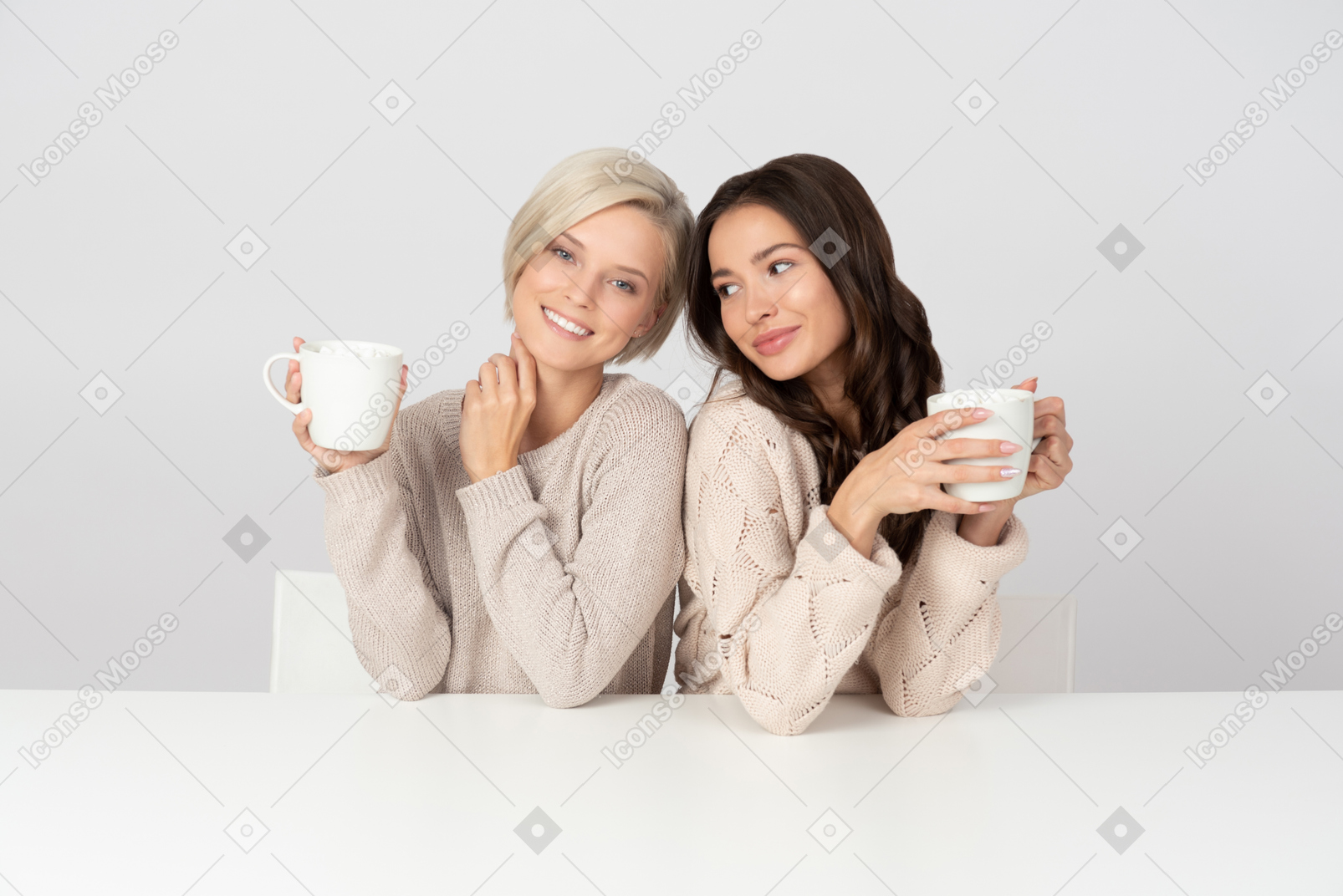 Young women embracing and drinking coffee