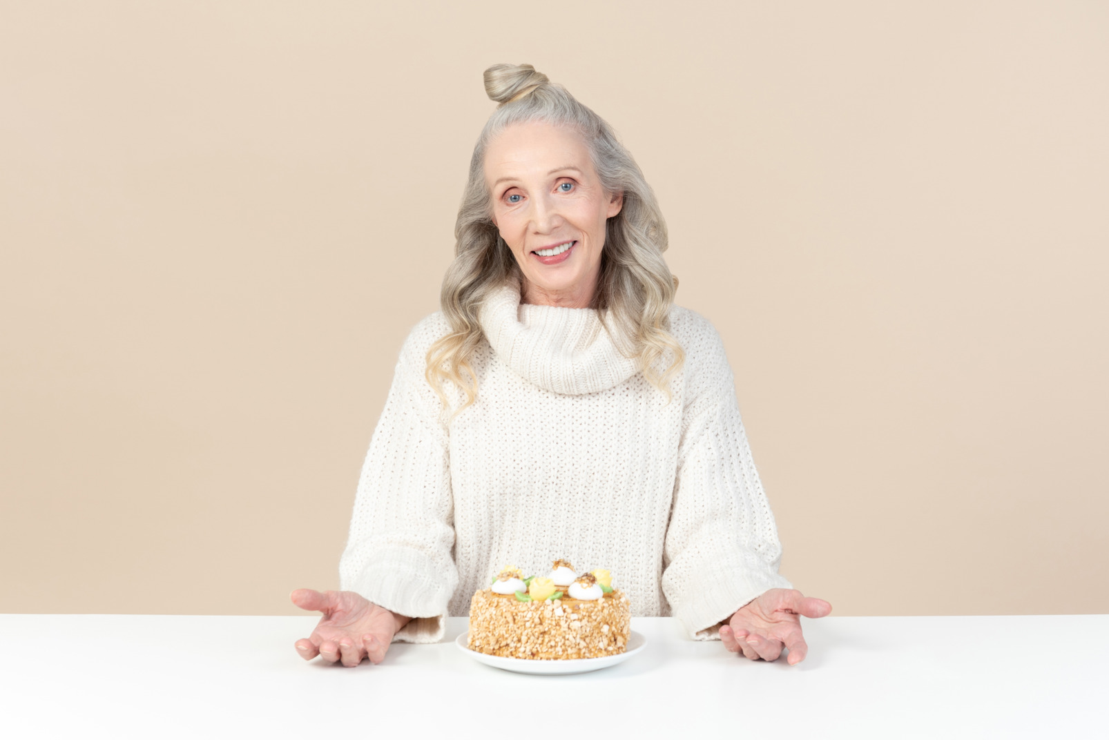 Old woman sitting at the table with cake on it