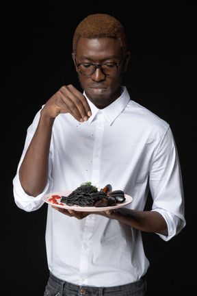 Vista frontal de un chef preparando su plato para servir