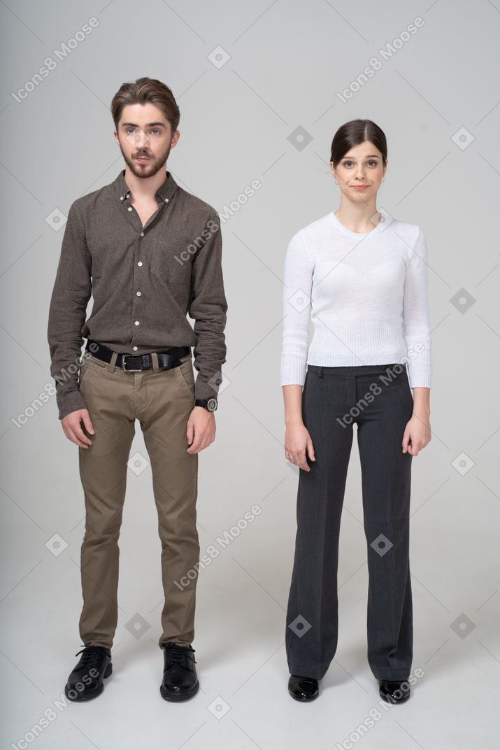Молодая пара в офисной одежде, стоя на месте, вид спереди