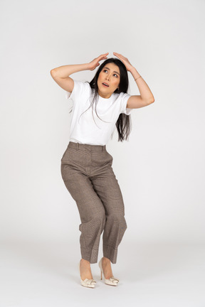 Front view of a scared young woman in breeches touching her head