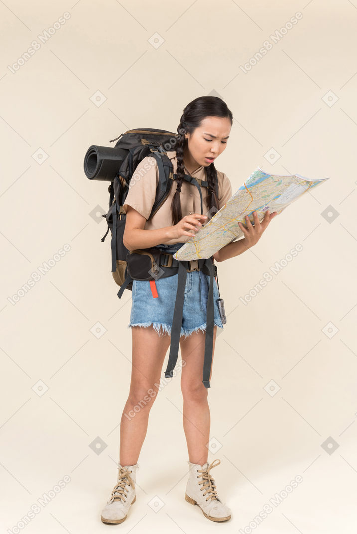 Young asian hiker reading the map