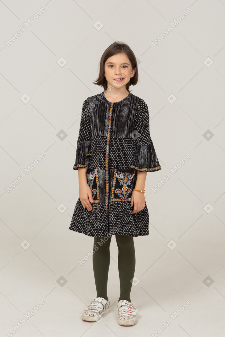 Front view of a little girl in dress clenching teeth