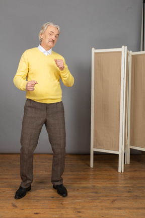 Front view of a dancing old man clenching fists