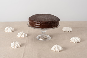 Chocolate cake on glass cake stand and zephyr