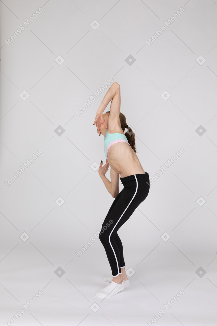 Three-quarter view of a teen girl in sportswear leaning forward
