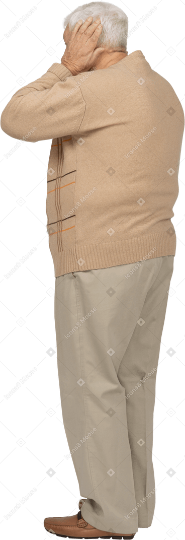 Old man in casual clothes covering ears with hands