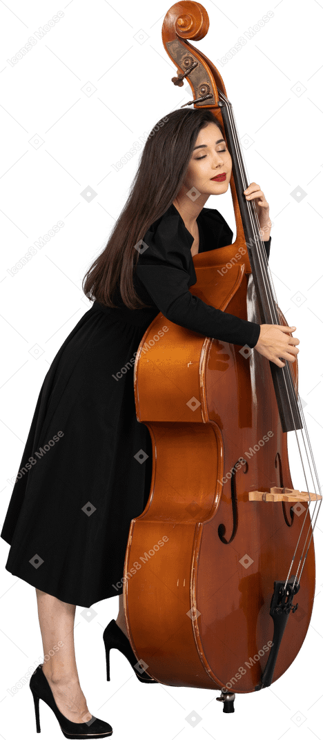 一位年轻的女音乐家，穿着黑色的连衣裙，抱着她的双低音的侧视图