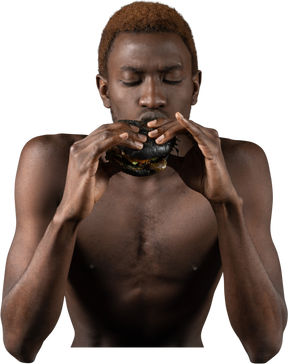 ハンバーガーを食べる若いアフロ男の正面図