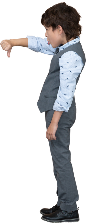 Vue latérale d'un garçon en costume gris montrant le pouce vers le bas