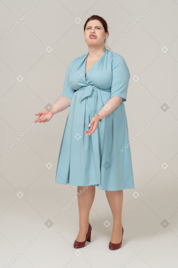 Front view of a woman in blue dress making faces