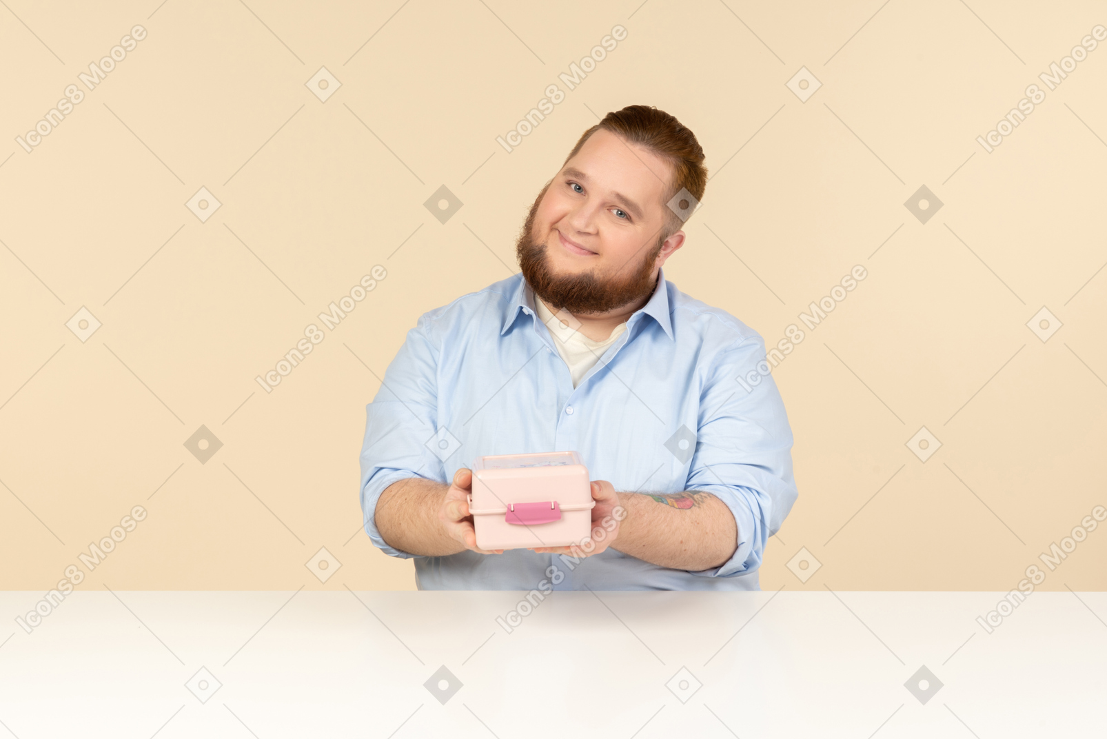 Большой человек сидит за столом и держит коробку для завтрака