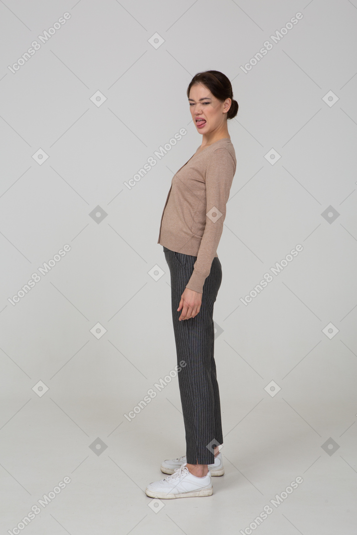 Vista laterale di una giovane donna smorfie in pullover beige