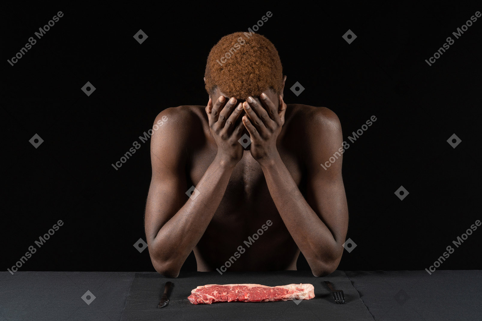 坐在肉附近的一个内向的年轻非洲人的正面图