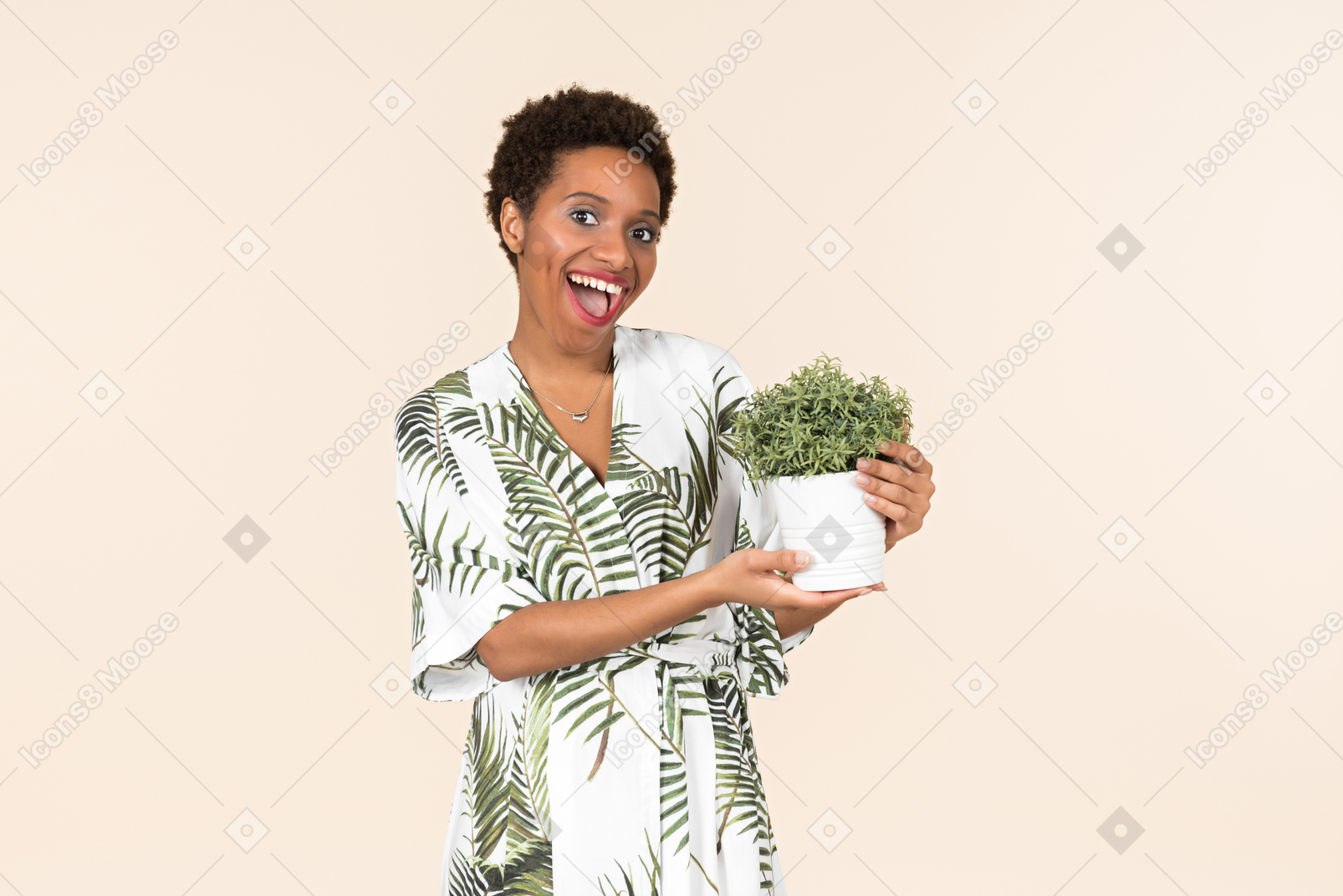 Young black short haired woman in a dressing gown, holding a potted plant