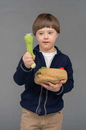 Little boy holding stuffed leek toy