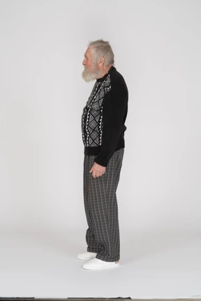 Side view of standing elderly man in dark clothes